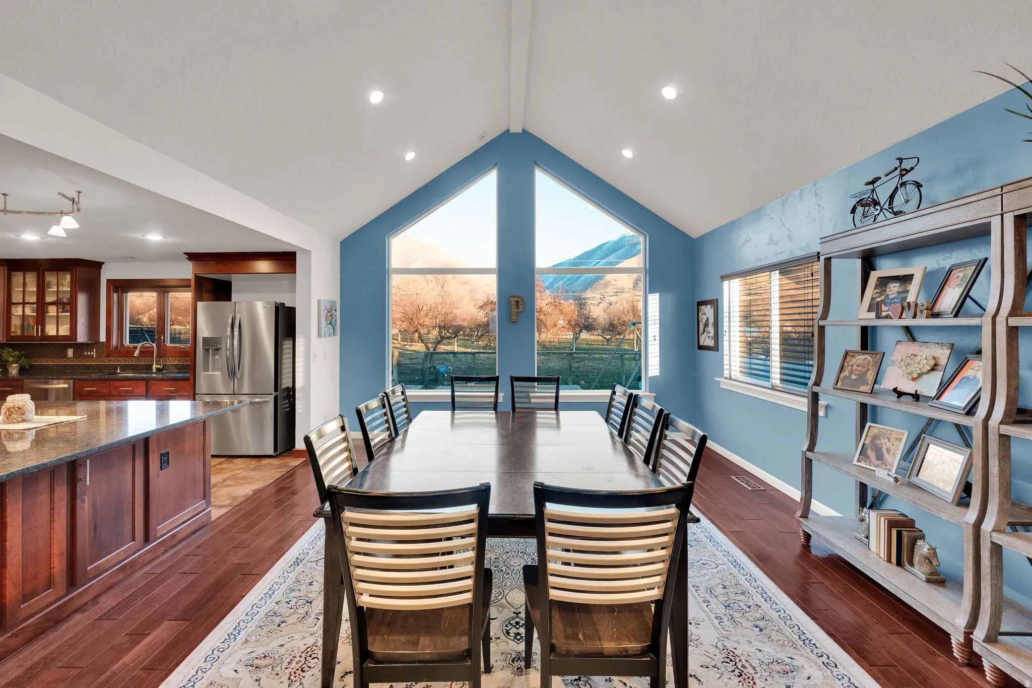 Dining area featuring dark wood-style floors, vaulted ceiling, and recessed lighting