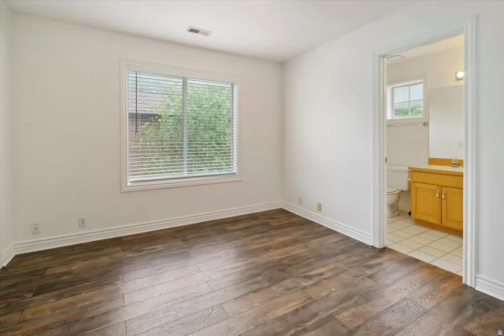 Bedroom with dark wood-style flooring and ensuite bathroom