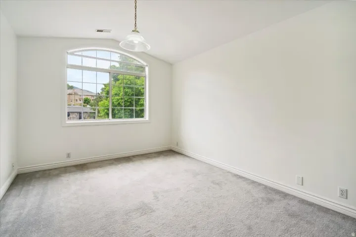 Bedroom with lofted ceiling and carpet