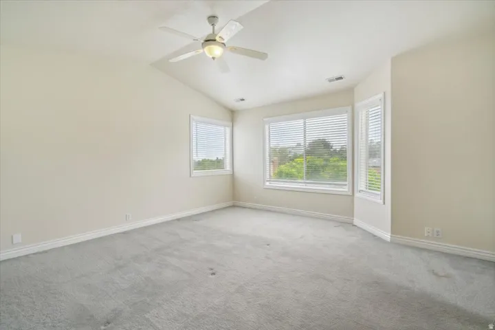 Master Bedroom with lofted ceiling, carpet flooring, and a ceiling fan