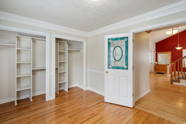 Office with light wood-type flooring, stairs, a textured ceiling, and crown molding