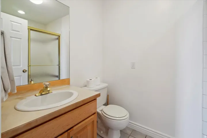 Full bathroom featuring vanity, a shower stall, and light tile patterned floors