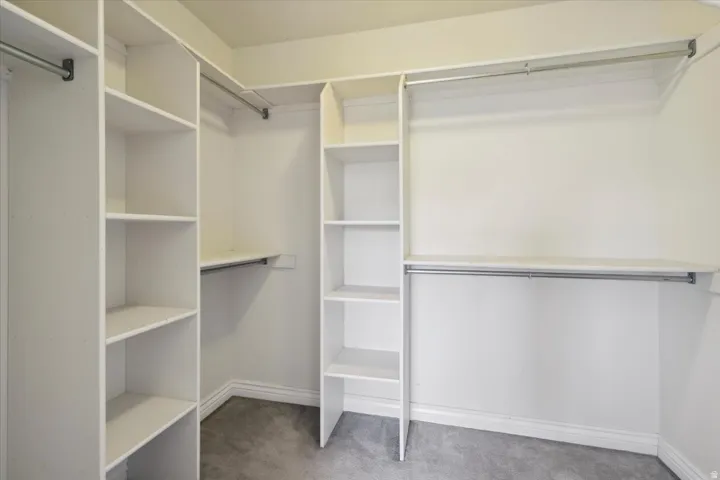 Walk in closet with dark colored carpet