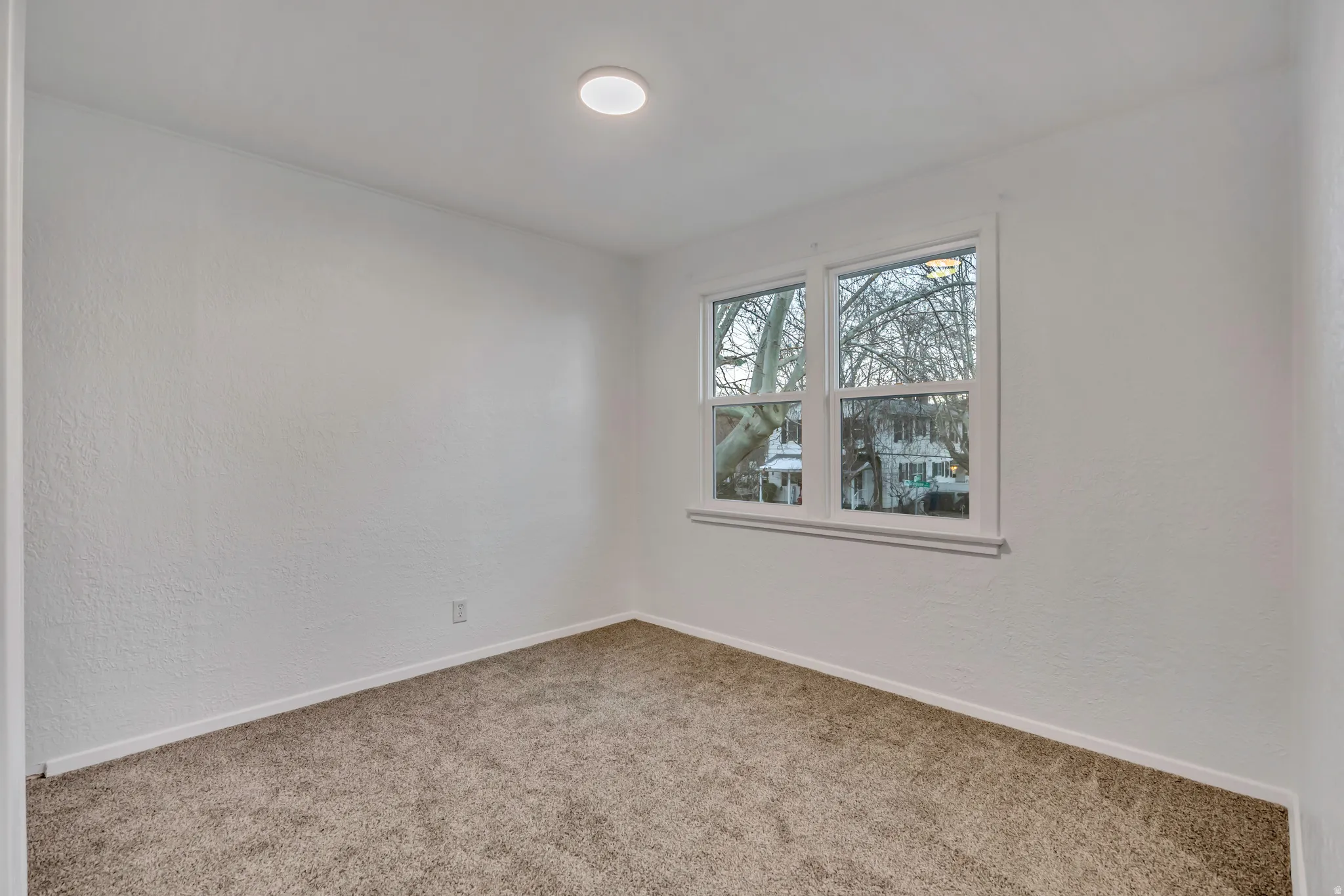 Spare room with a textured wall and carpet floors