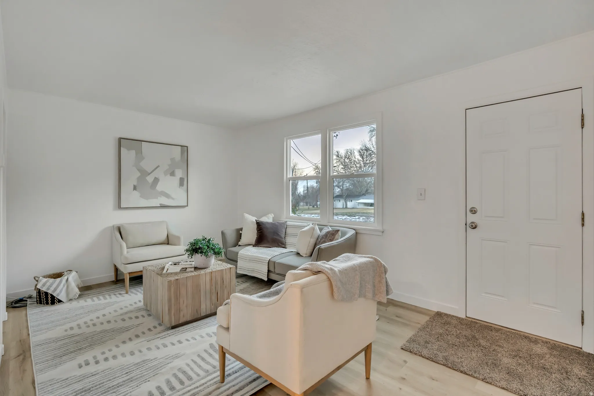 Living area featuring baseboards and light wood-type flooring