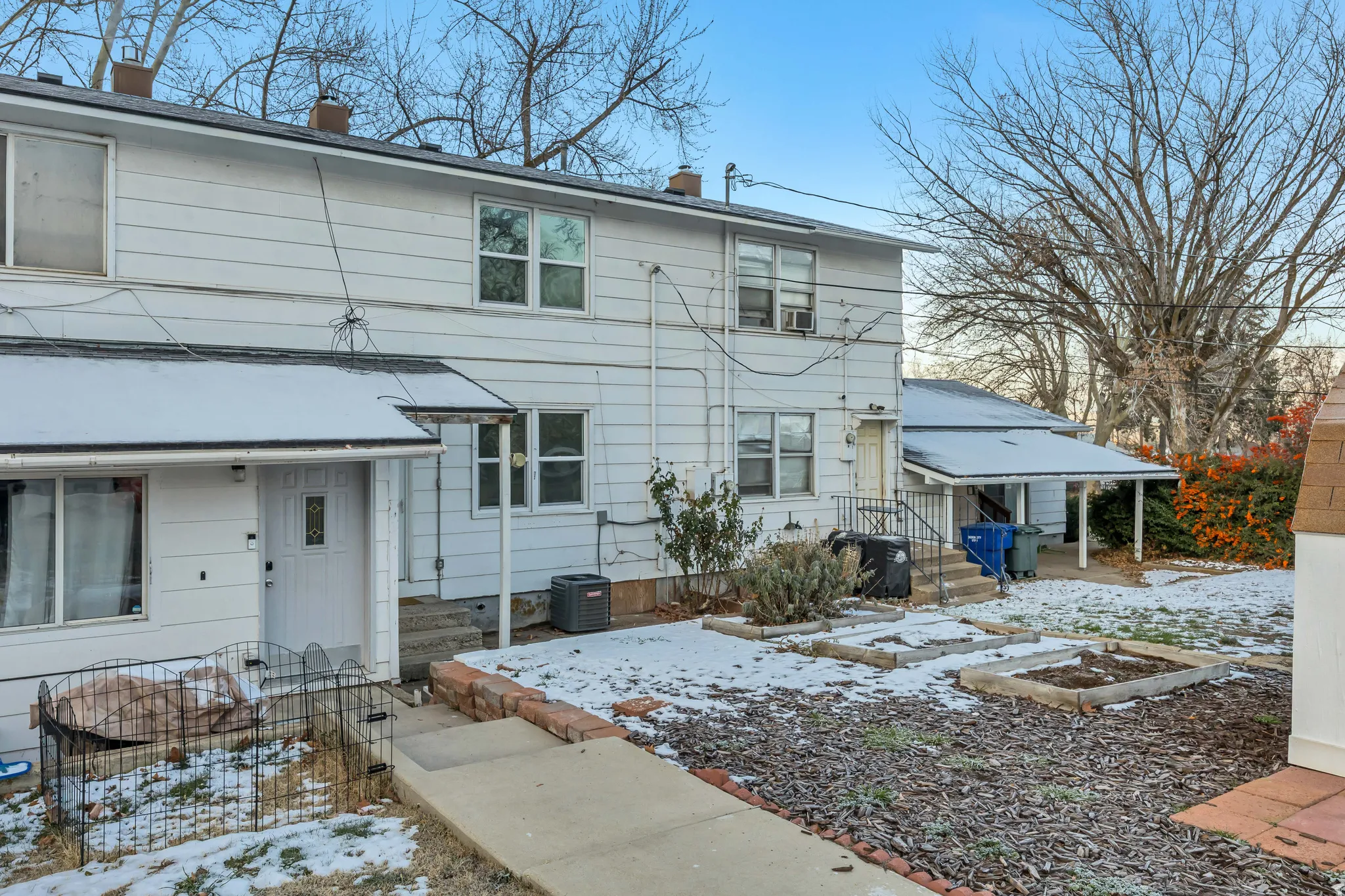 Snow covered property with a chimney and a garden