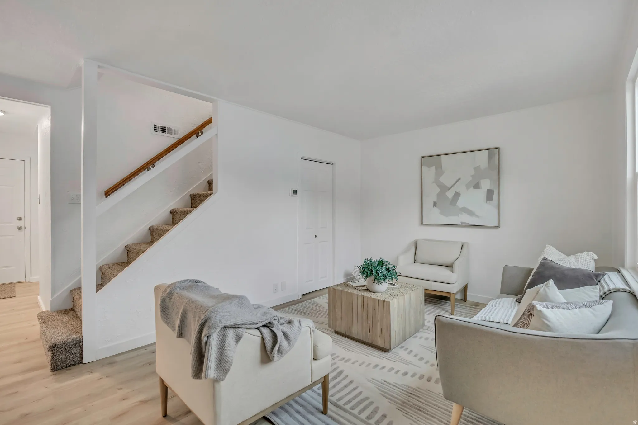 Living room with stairway and wood finished floors