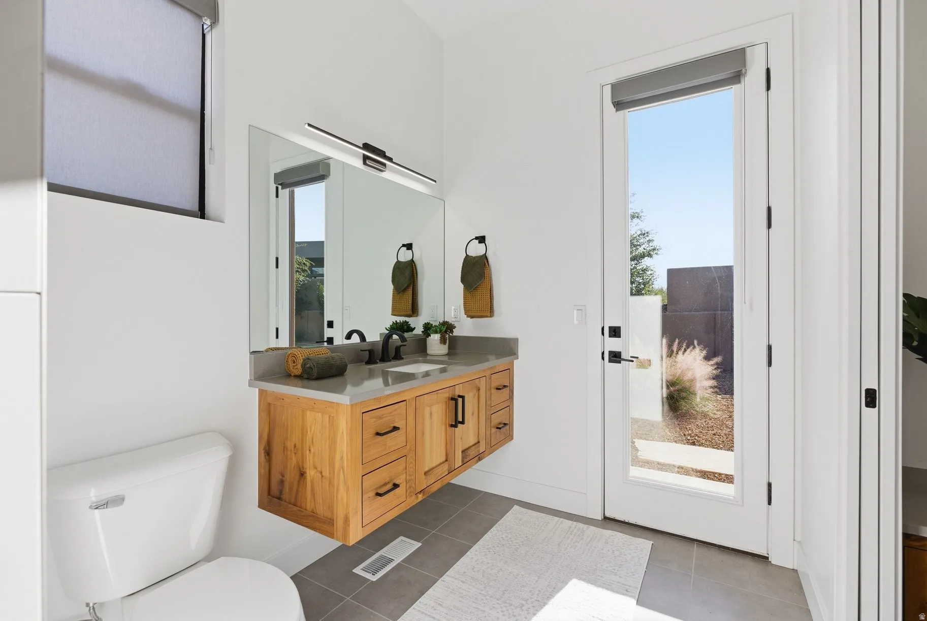 Bathroom with vanity and dark tile patterned flooring