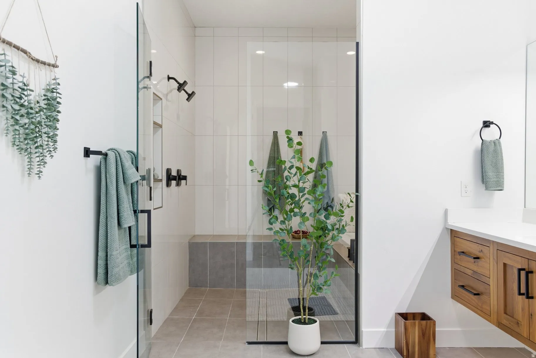 Bathroom featuring vanity, a shower stall, and light tile patterned floors