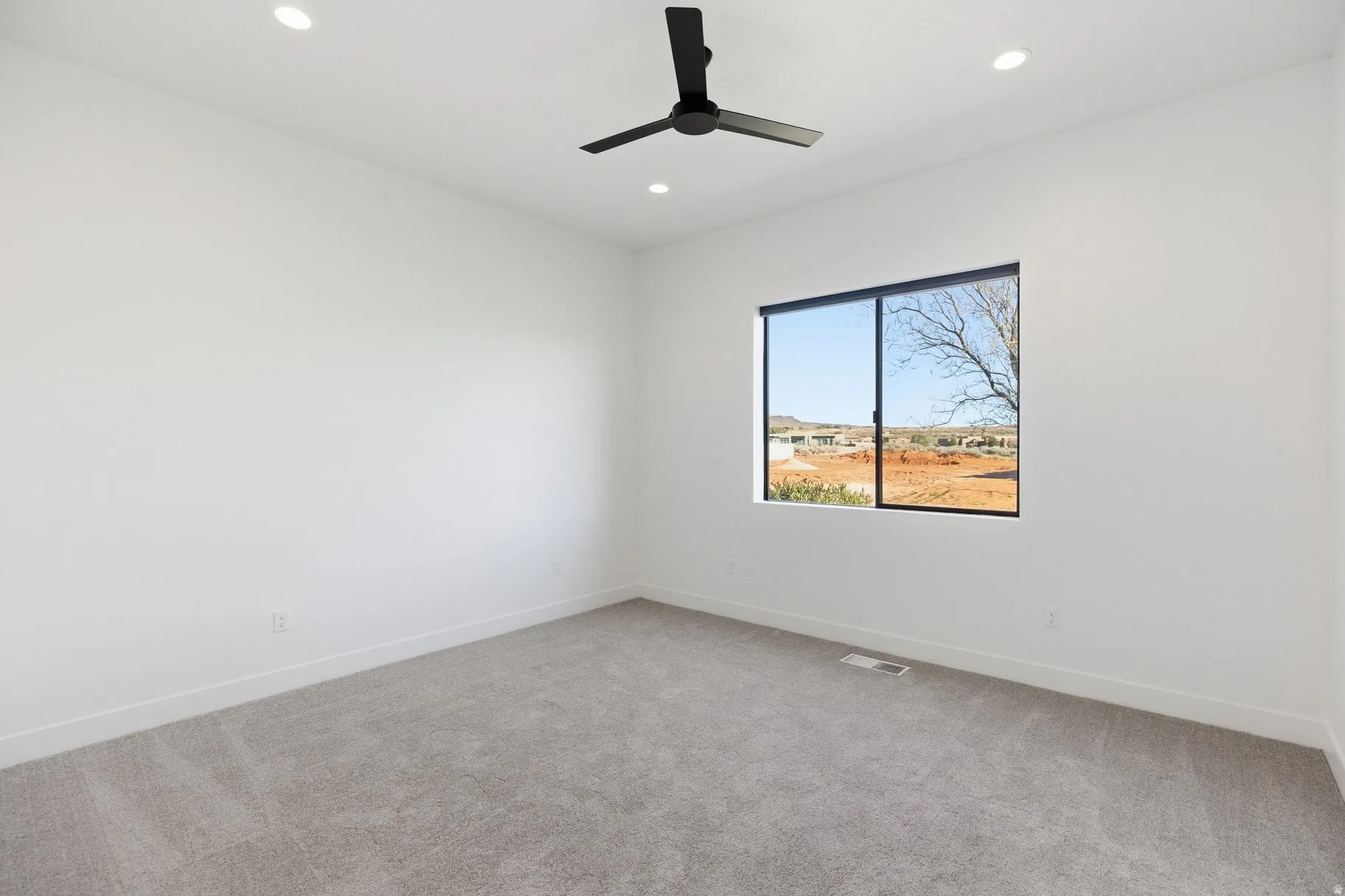 Empty room featuring light colored carpet, recessed lighting, and ceiling fan