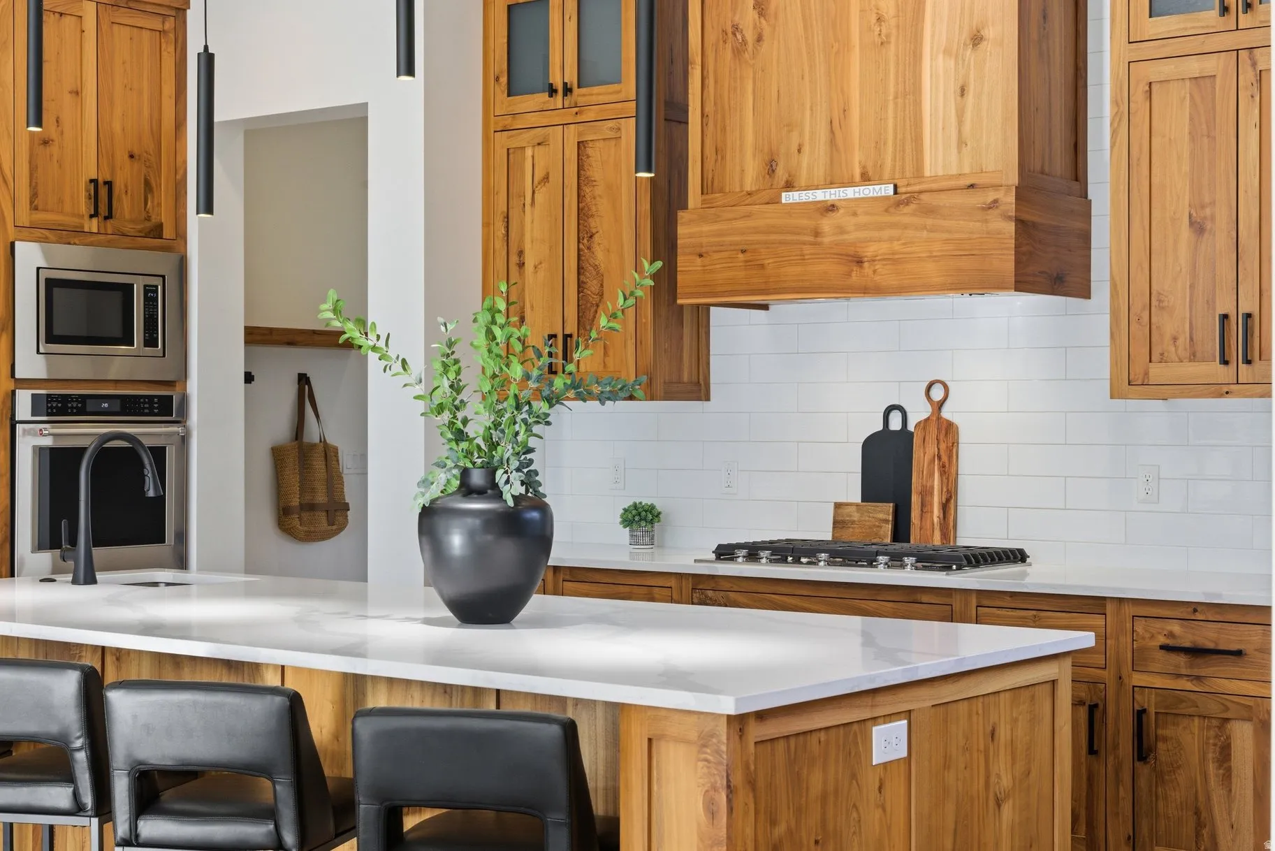Kitchen with glass insert cabinets, wood finish cabinetry, stainless steel appliances, a breakfast bar area, and tasteful backsplash