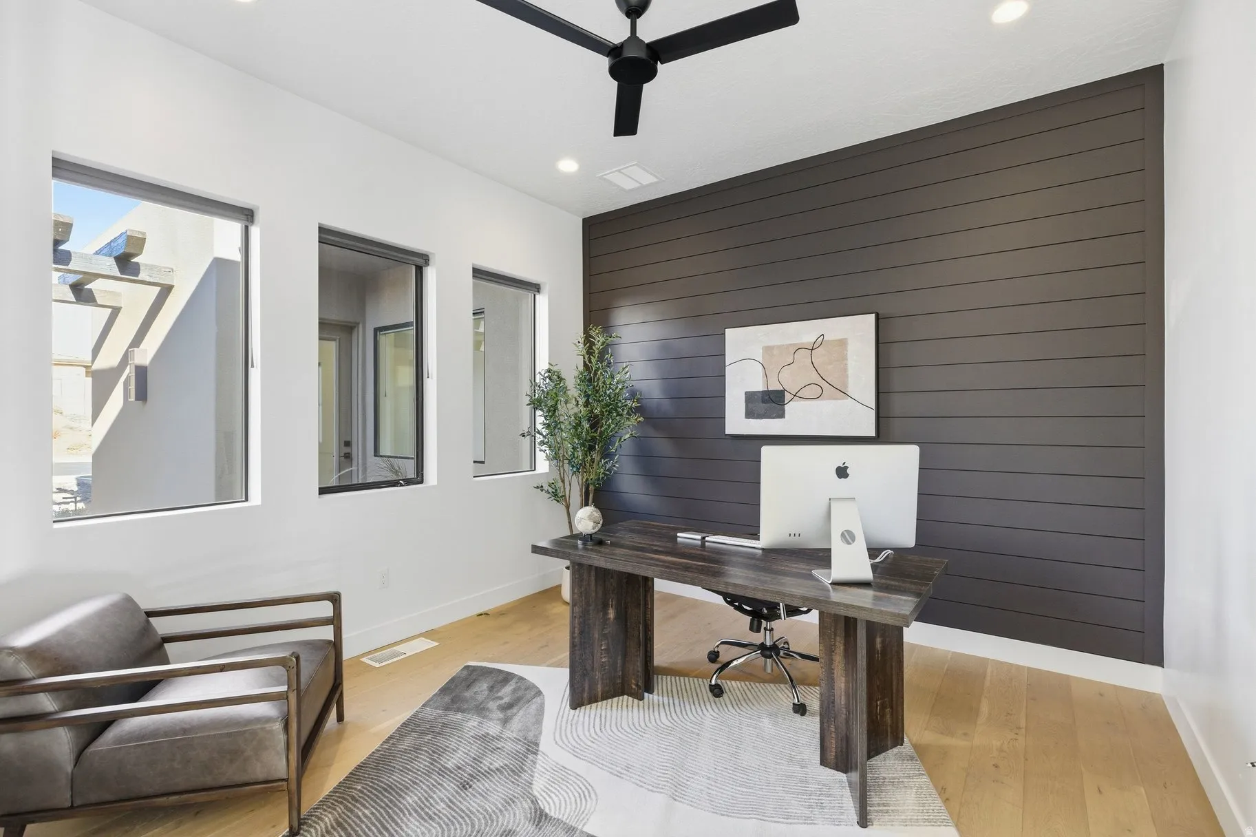 Home office with wood walls, ceiling fan, recessed lighting, light wood-style floors, and an accent wall