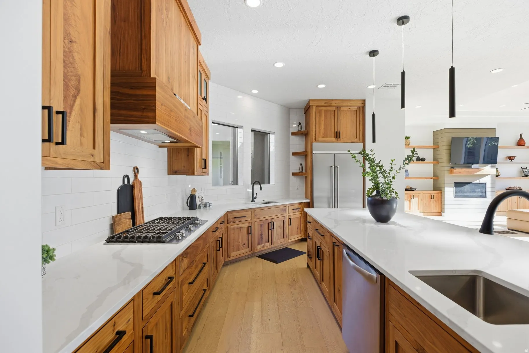 Kitchen featuring light wood finished floors, light stone counters, wood finish cabinets, and stainless steel appliances