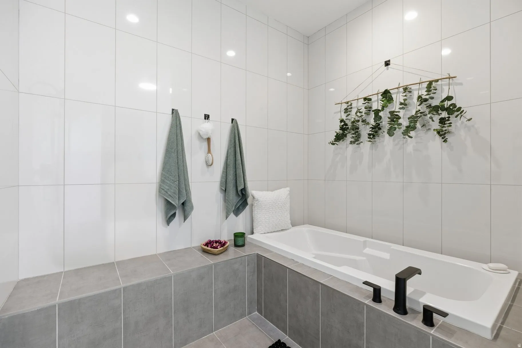 Bathroom featuring tile walls and a garden tub