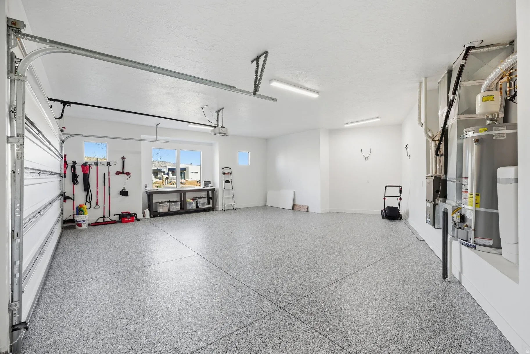 Garage featuring gas water heater and heating unit