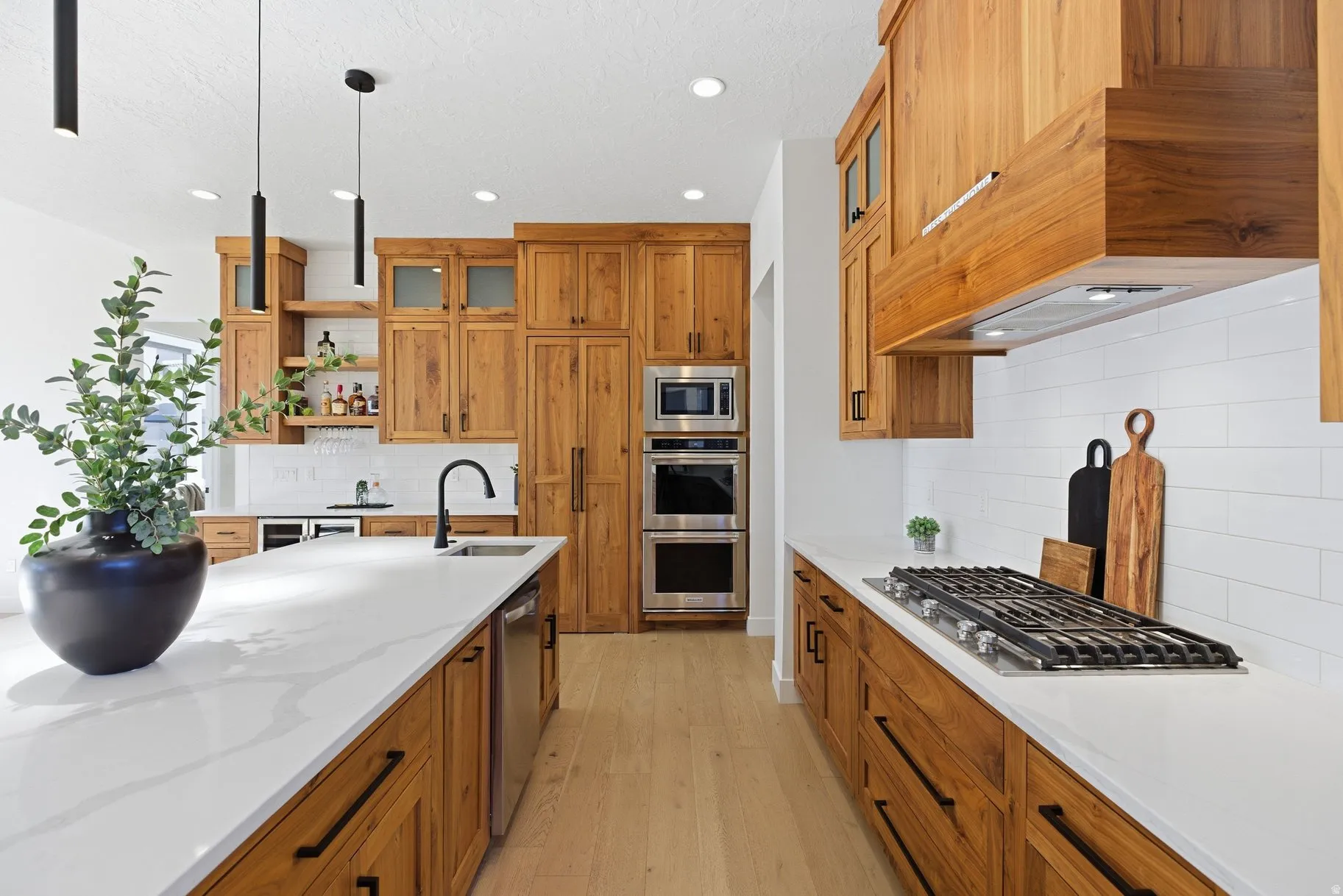Kitchen featuring glass insert cabinets, open shelves, light wood-style flooring, and light stone counters