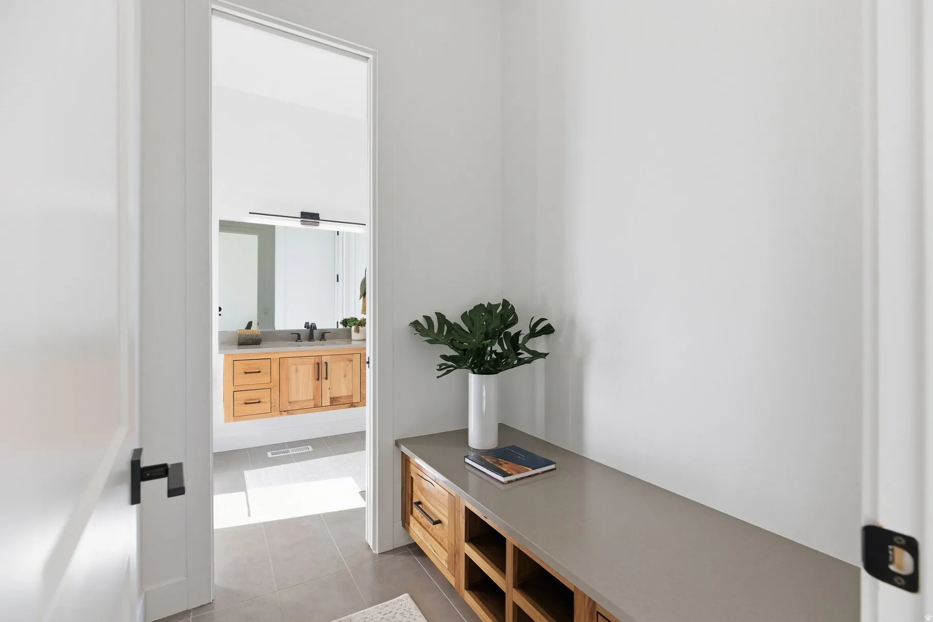 Corridor featuring light tile patterned flooring and a sink