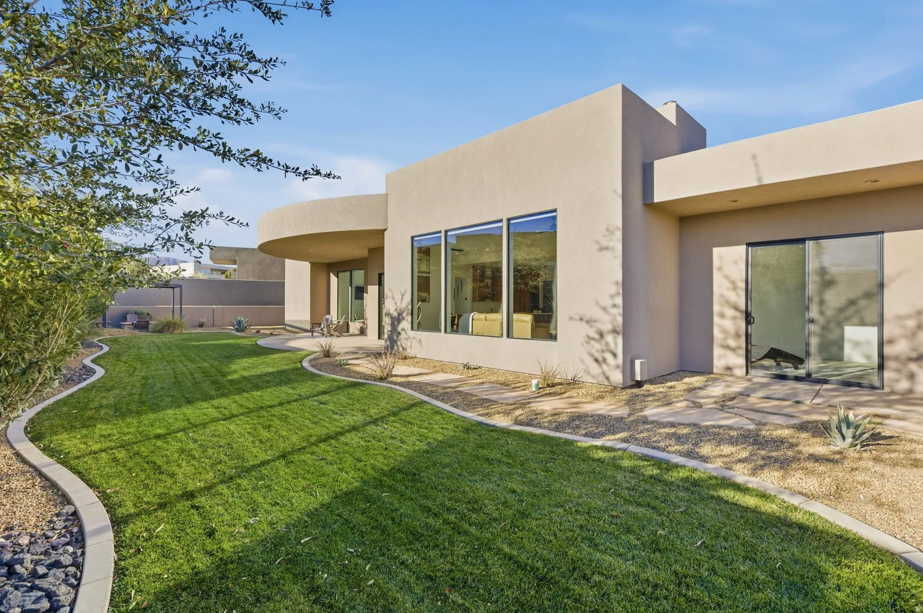 Rear view of house with stucco siding and a patio