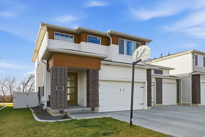 View of front of property featuring concrete driveway and an attached garage