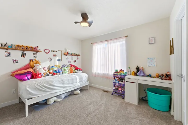 Bedroom with light carpet and a ceiling fan