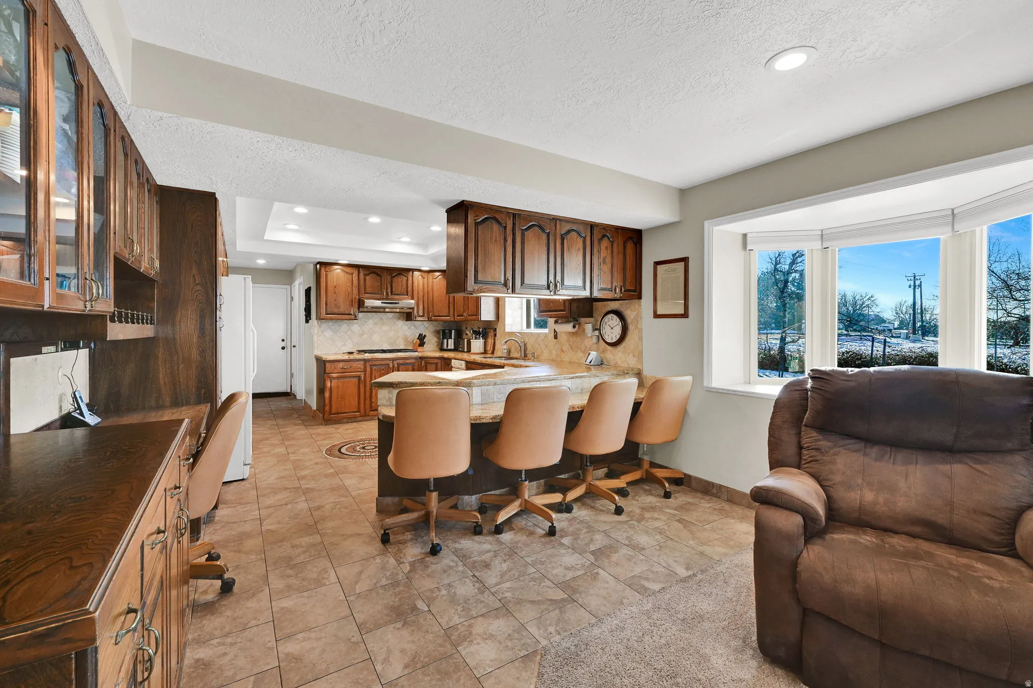 Kitchen with a kitchen breakfast bar, a peninsula, recessed lighting, open floor plan, and plenty of natural light