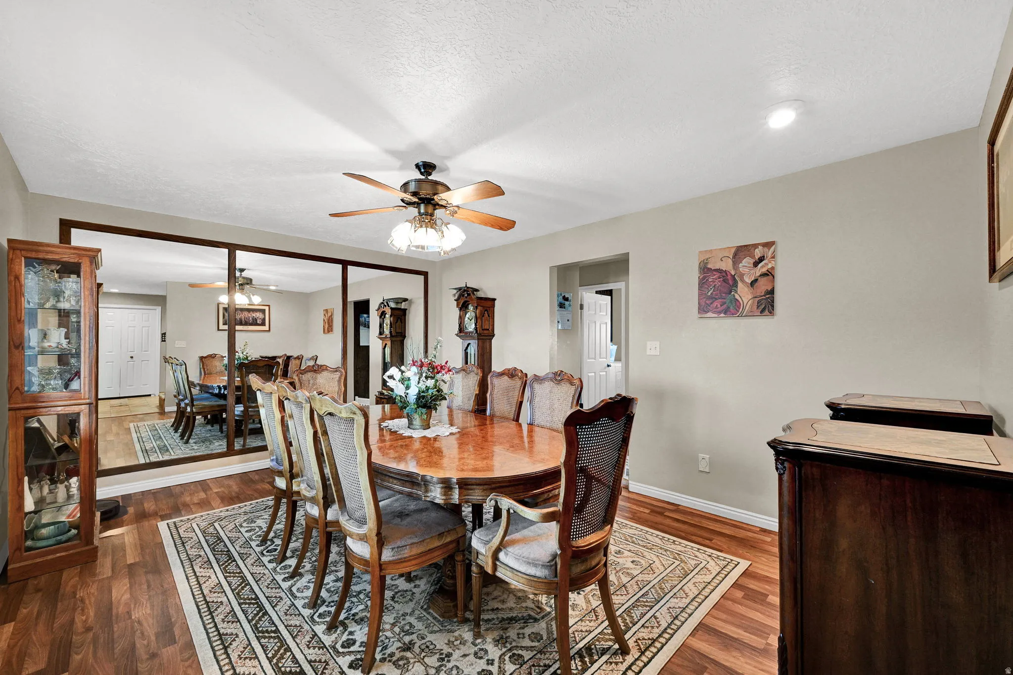 Left Entrance Shown Furnished Dining area featuring ceiling fan, dark wood finished floors, and a textured ceiling