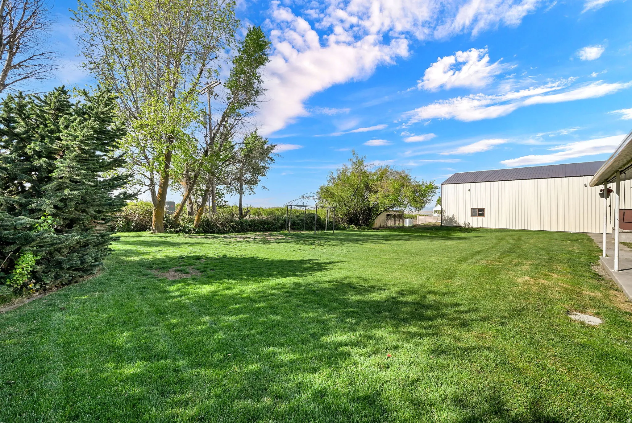 SPACIOUS BACKYARD RV GARAGE IN BACKGROUND