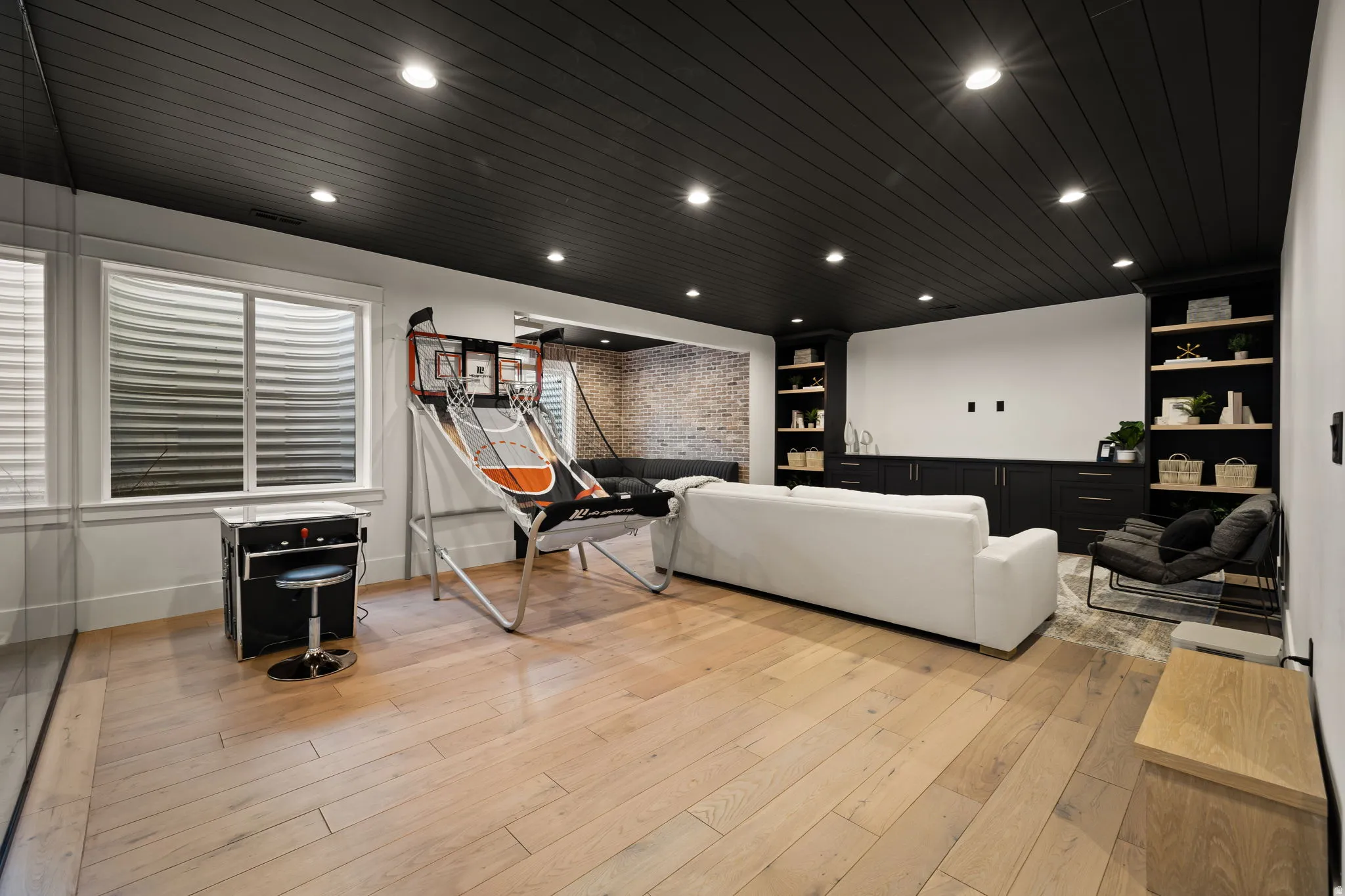 Home theater room featuring built in features, wooden ceiling, light wood finished floors, recessed lighting, and brick wall
