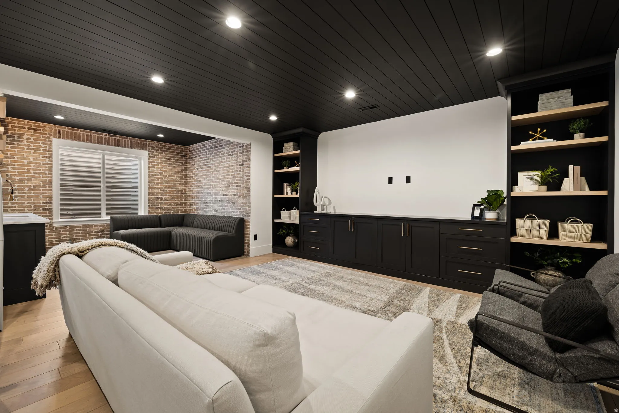Cinema room with brick wall, recessed lighting, light wood-style floors, wood ceiling, and bar with sink