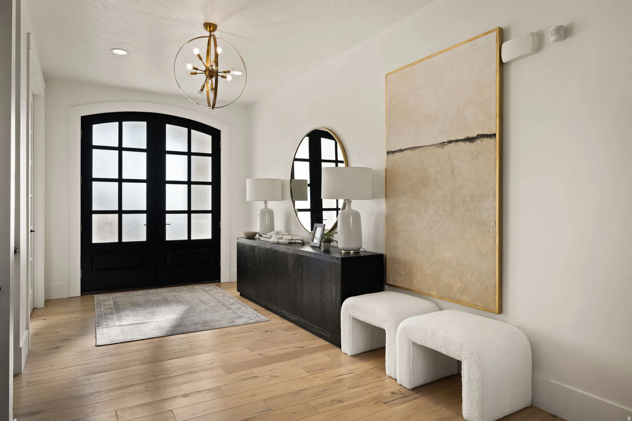 Foyer featuring a chandelier, light wood-style floors, and french doors