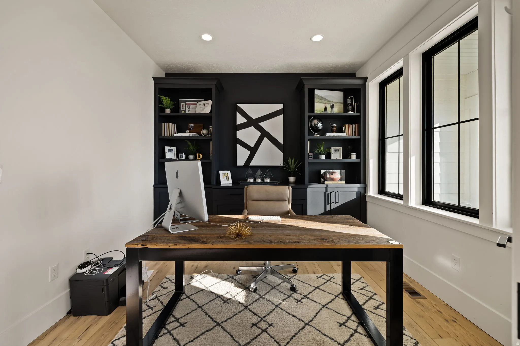 Office space with light wood finished floors, recessed lighting, and built in shelves