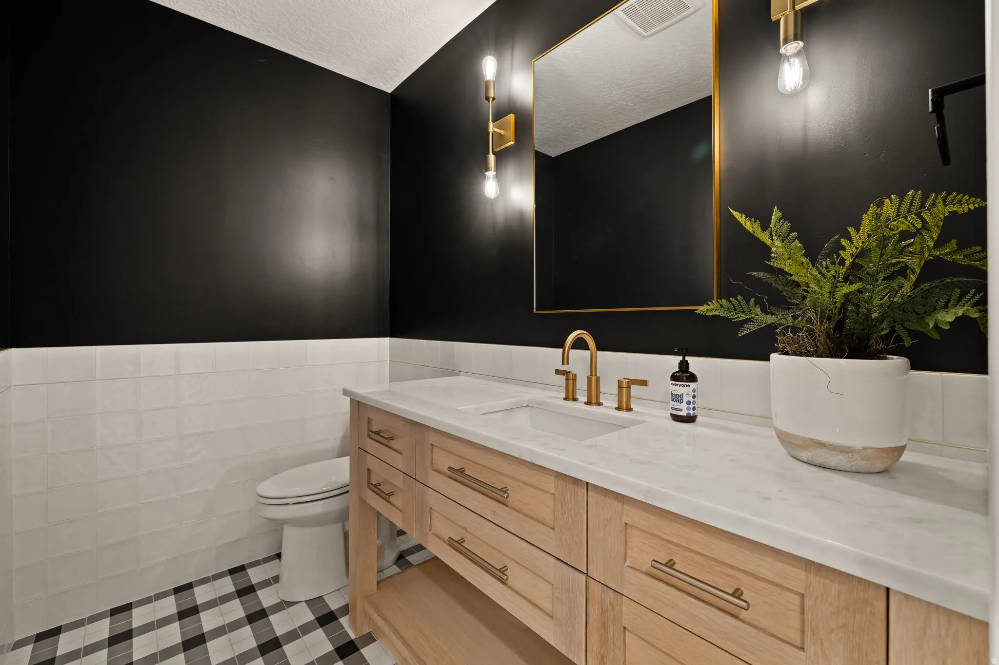 Bathroom with vanity, wainscoting, a textured ceiling, and light tile patterned floors