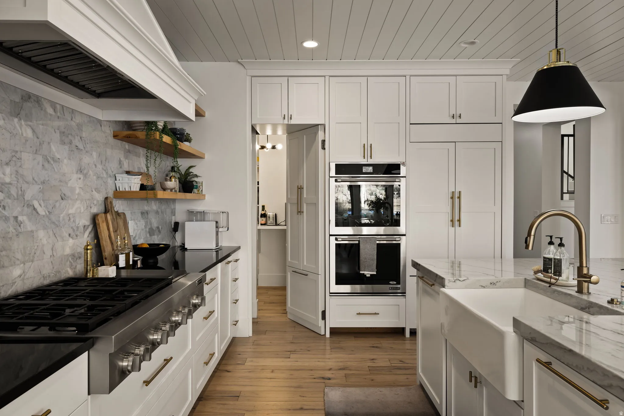 Kitchen featuring decorative backsplash, dark stone counters, white cabinetry, custom range hood, and wood ceiling
