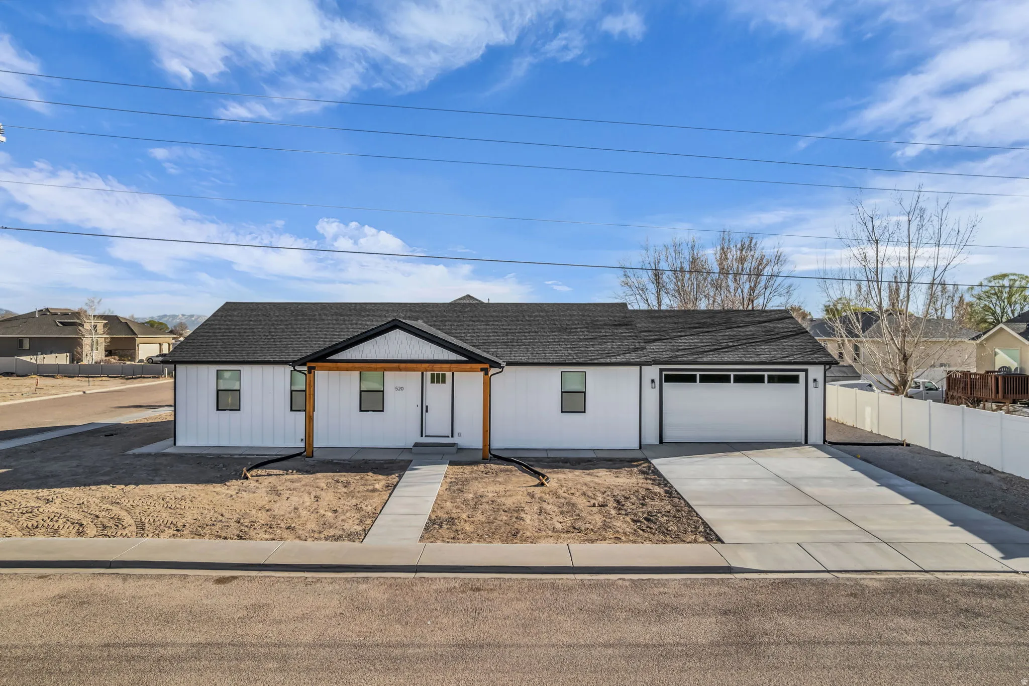 View of front of house featuring driveway, covered porch, a garage, and roof with shingles