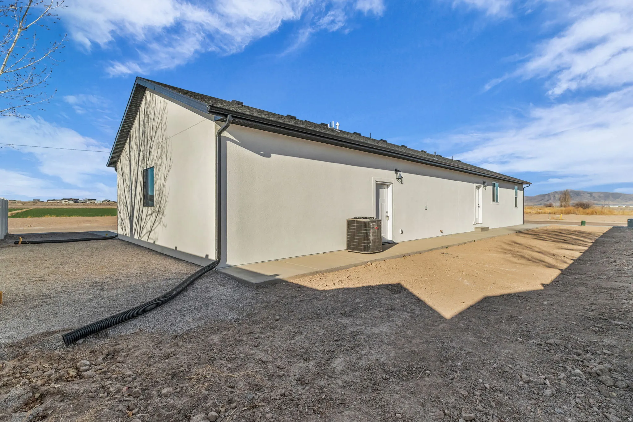 Back of house featuring a mountain view and stucco siding