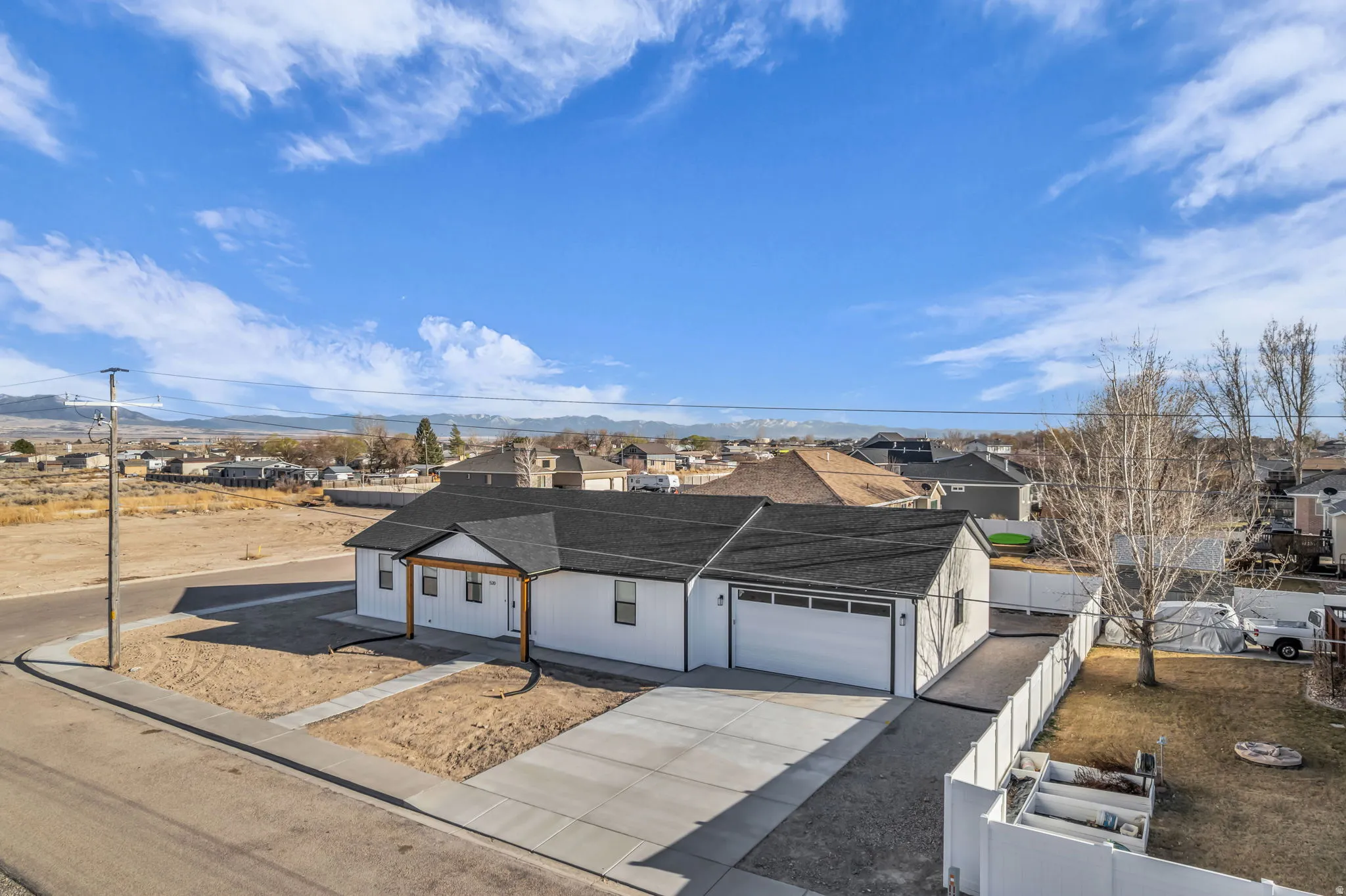 View of front of property featuring driveway, a garage, a residential view, and a shingled roof