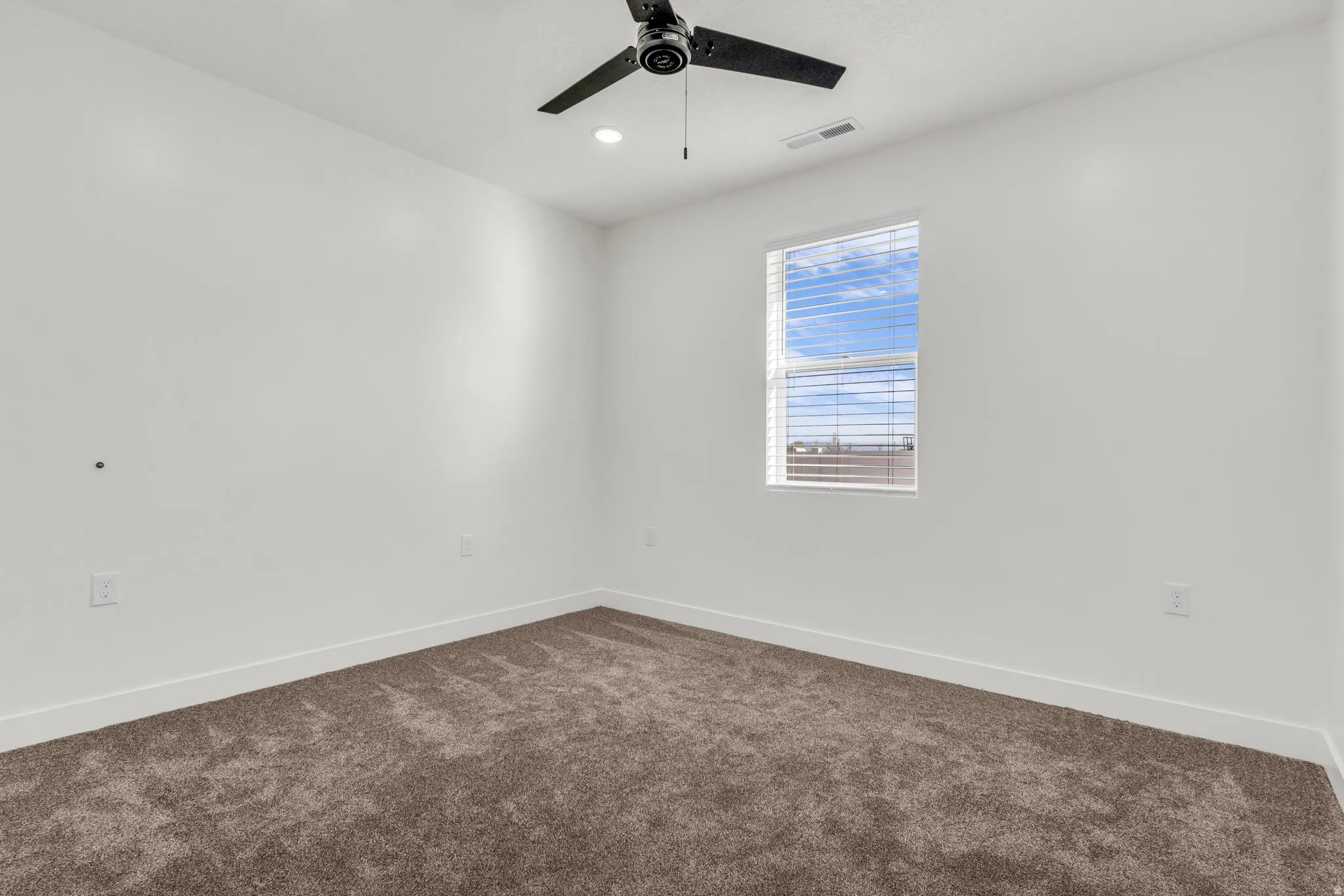 Spare room with dark colored carpet, ceiling fan, and recessed lighting