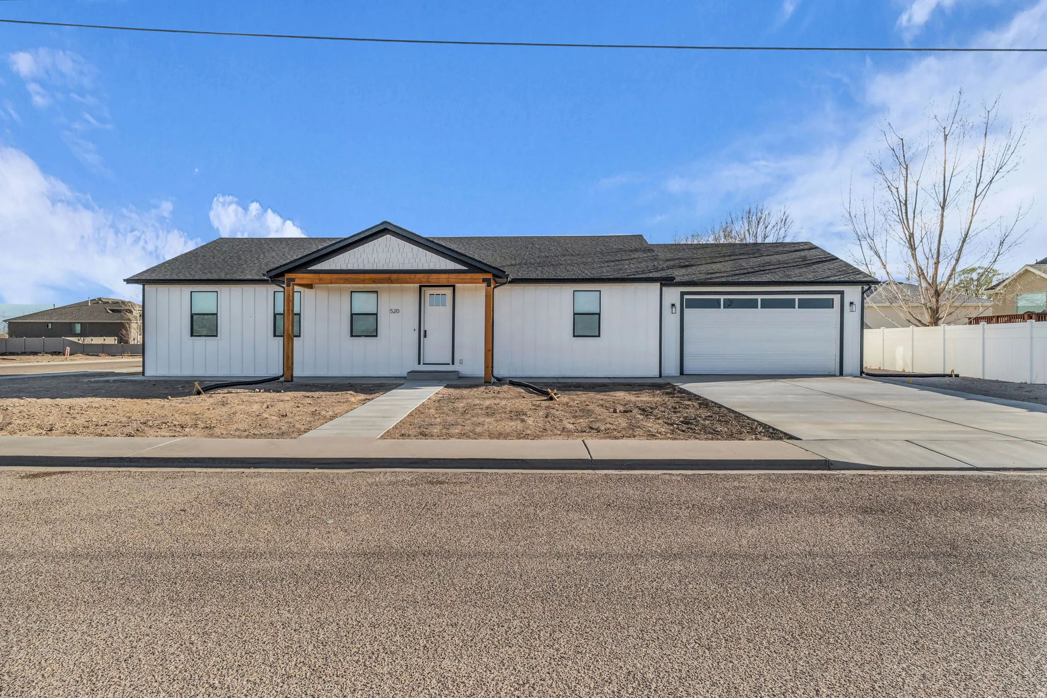 View of front of house with covered porch, concrete driveway, a garage, and roof with shingles