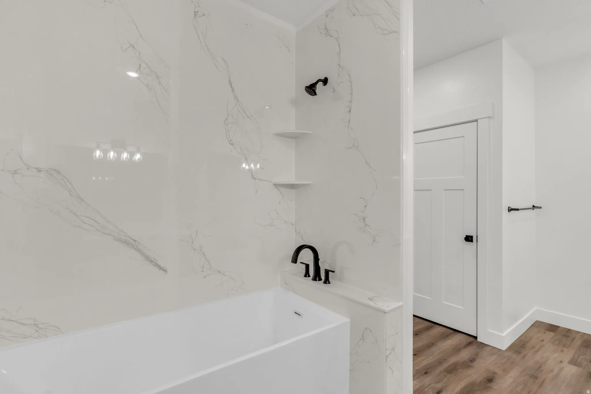 Full bath featuring a tub to relax in and light wood finished floors