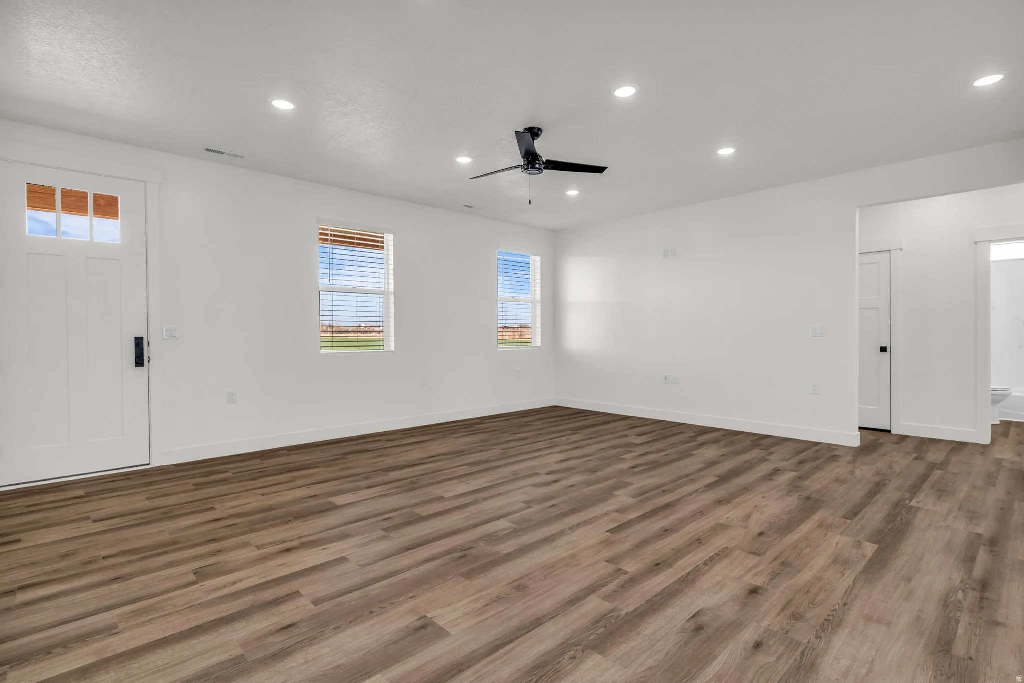 Empty room featuring recessed lighting, a ceiling fan, and dark wood-style flooring