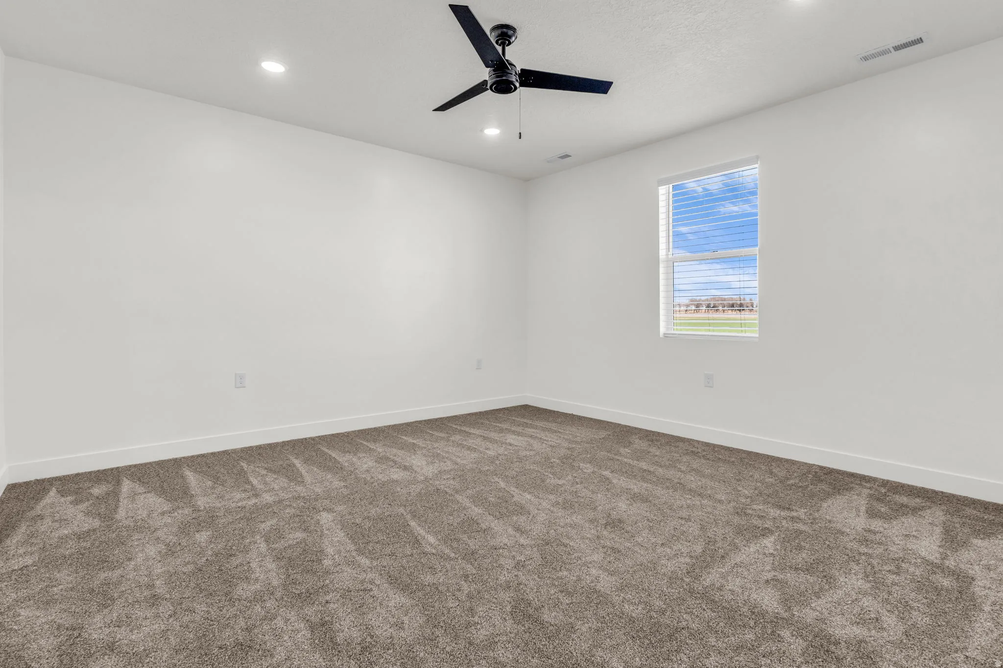 Spare room featuring dark carpet, recessed lighting, and ceiling fan