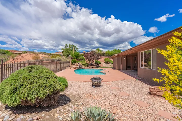 View of pool with a patio area, a fenced backyard, and a fire pit