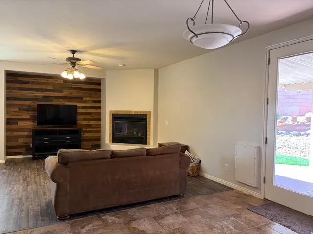 Living area with a tile fireplace and a ceiling fan