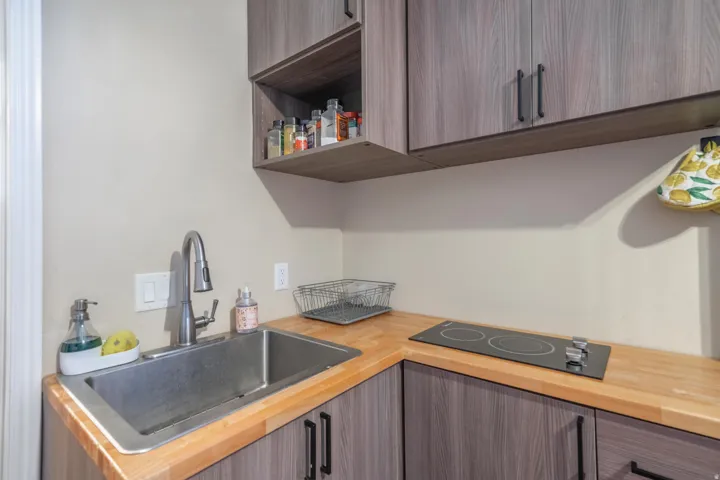Casita Kitchen with open shelves, modern cabinets, and black electric stovetop