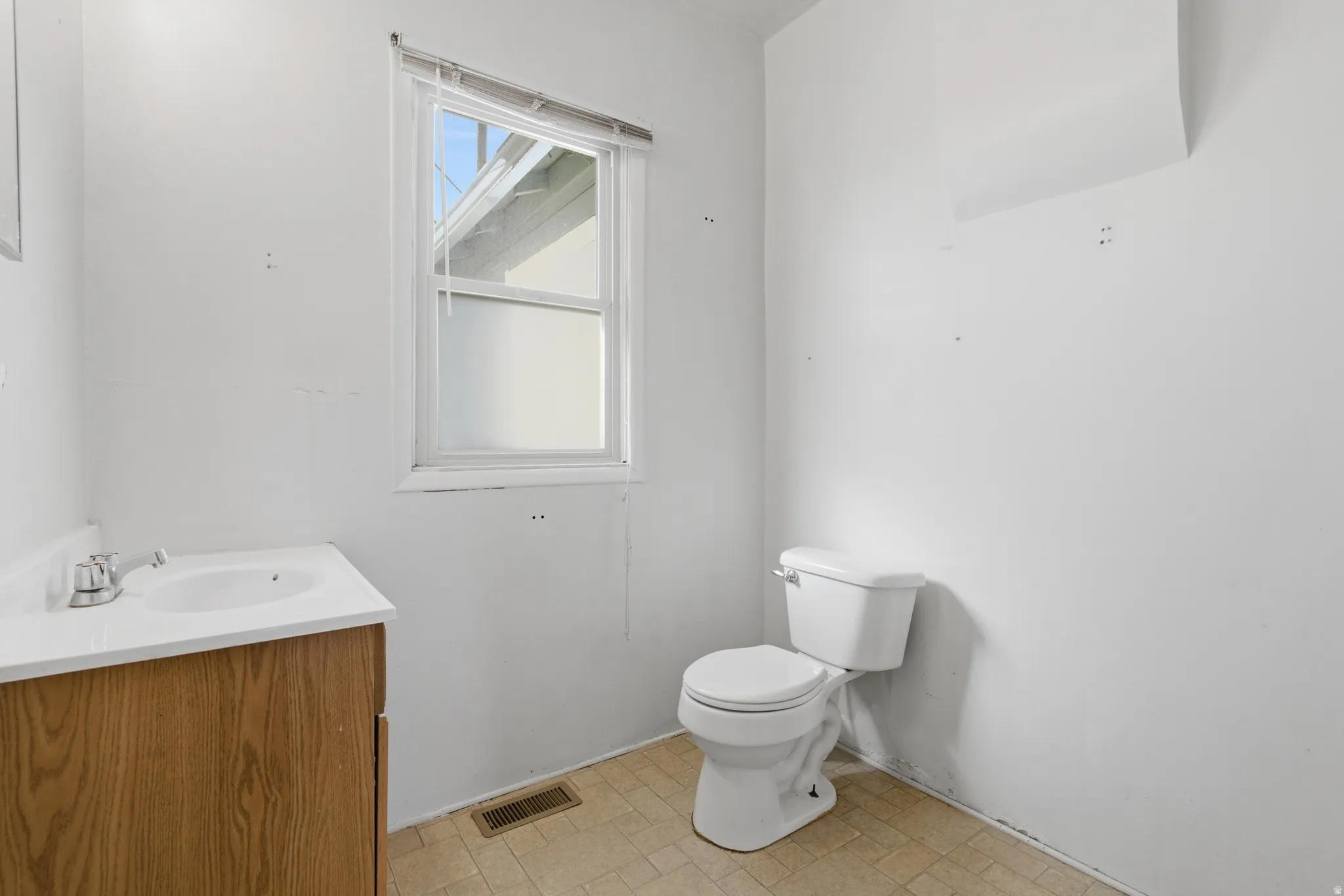 Half bathroom featuring vanity and toilet