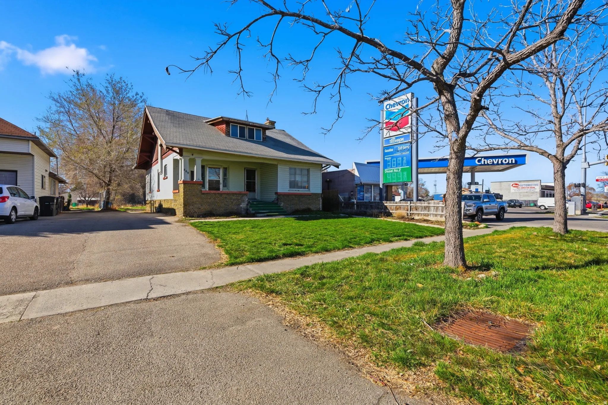 View of front of property featuring a front yard, brick siding, and a porch