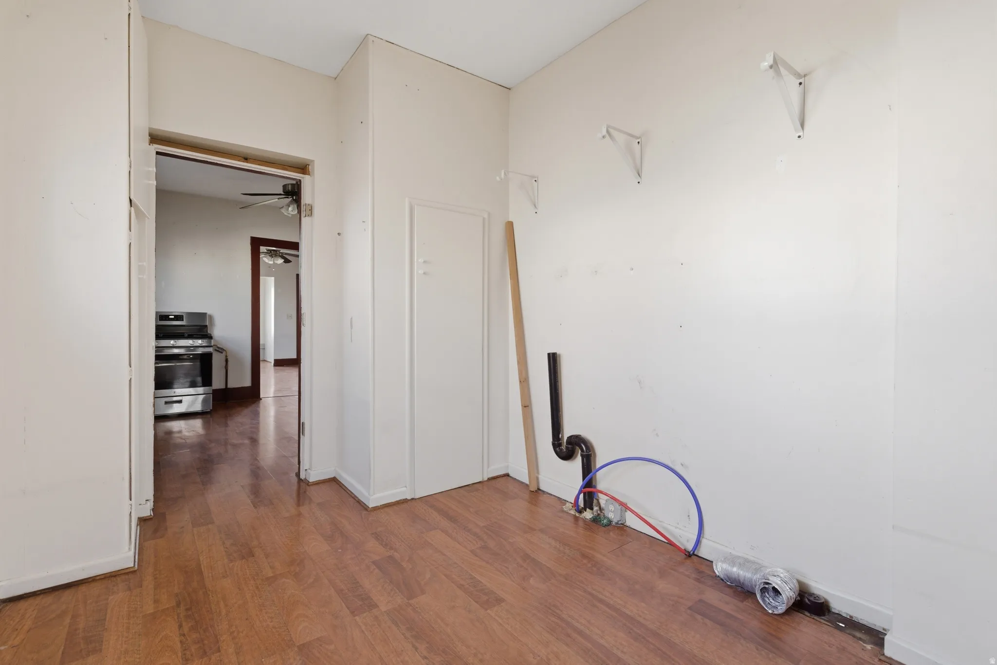 Corridor featuring dark wood-type flooring and baseboards