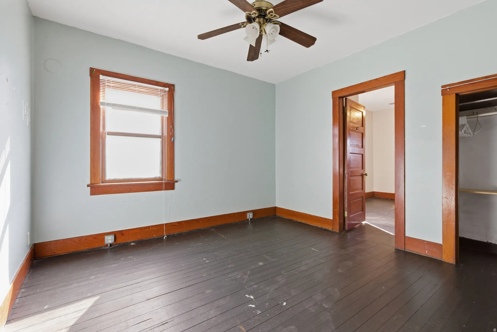 Unfurnished bedroom featuring dark wood finished floors and ceiling fan