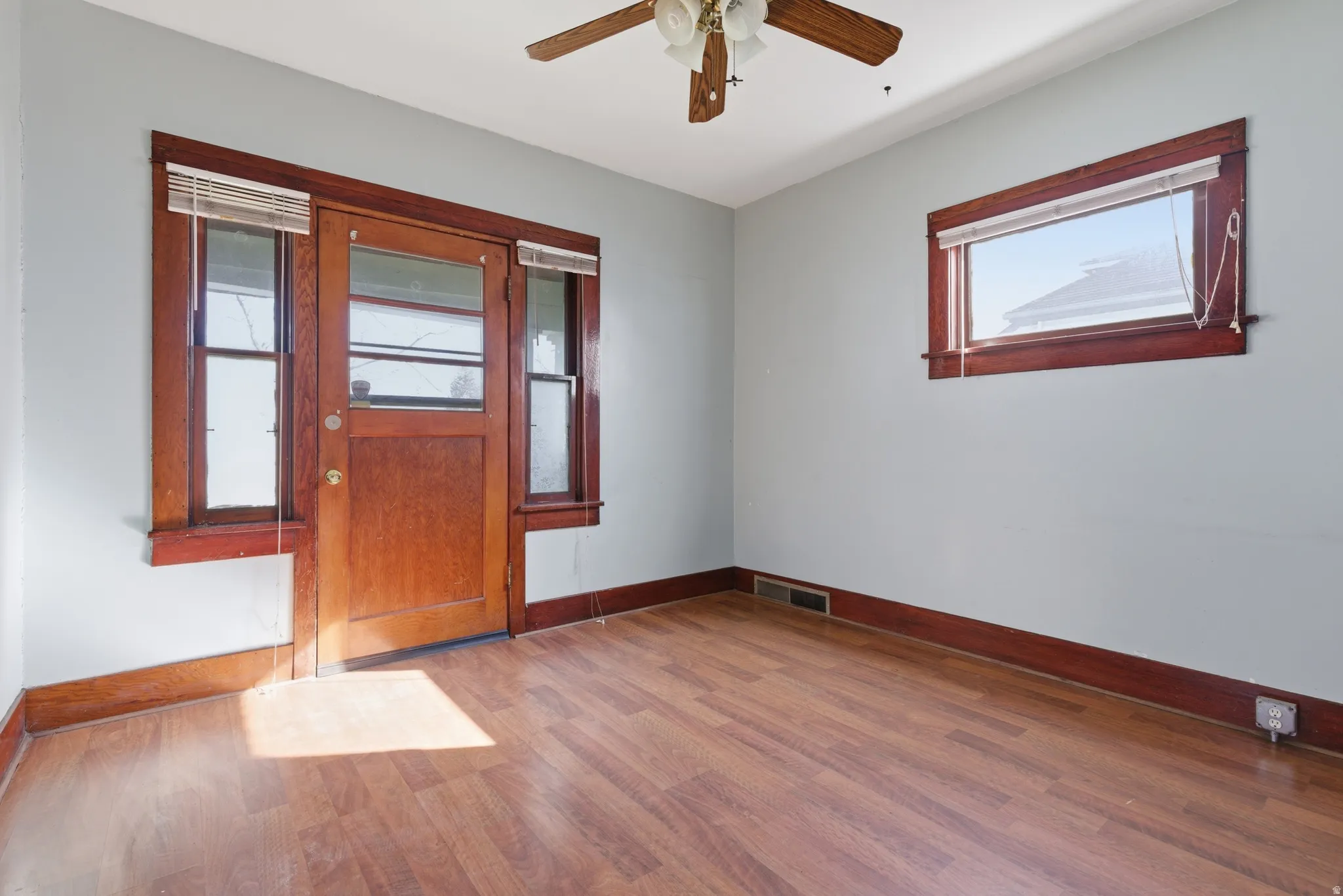Empty room with light wood-style floors and ceiling fan