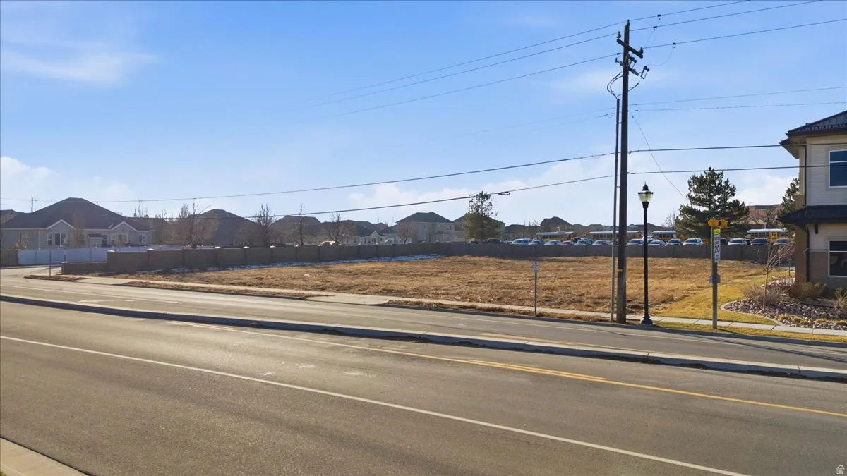 View of asphalt road featuring a residential view, sidewalks, and curbs